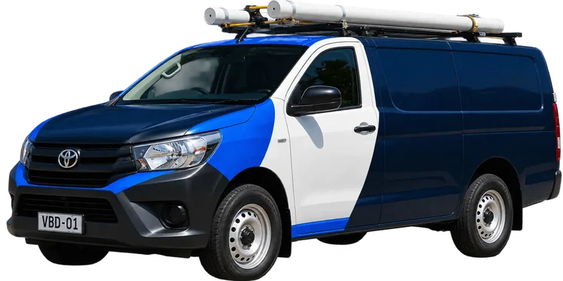 A licensed Lane Cove plumbing van loaded with pipe on the roof rack